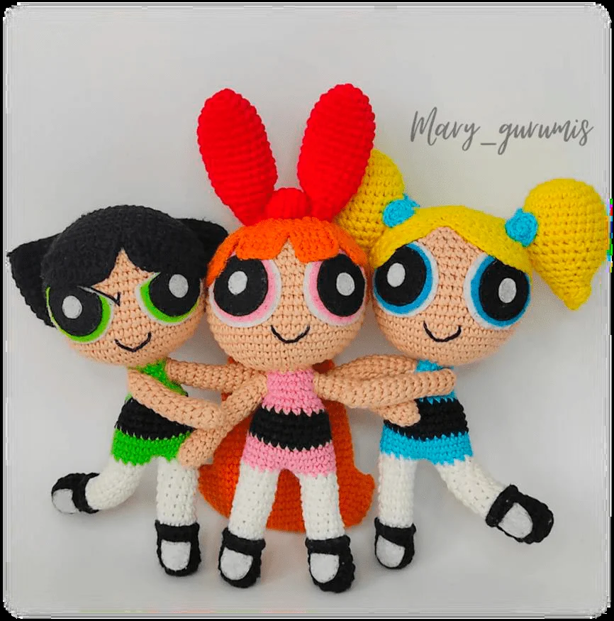 Tres Muñecas De Crochet Que Representan Personajes Animados Inspiradas En Las Chicas Superpoderosas Están Una Al Lado De La Otra Tienen Características Distintivas Que Incluyen Ojos Grandes Cabello Teñido Y Atuendos Uno Con Cabello Negro Y Un Vestido Verde Otro Con Cabello Rojo Y Un Vestido Rosa Y Otro Con Cabello Amarillo Y Un Vestido Azul