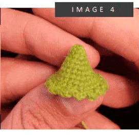 Un Primer Plano De La Mano De Una Persona Que Sostiene Un Objeto Pequeño Verde Y En Forma De Cono Que Parece Estar Tejido a Crochet O Tejido La Imagen Tiene La Etiqueta imagen 4 En La Parte Superior El Objeto Tiene Una Superficie Texturizada Y Se Asemeja a Un árbol De Navidad O Un Pequeño Sombrero