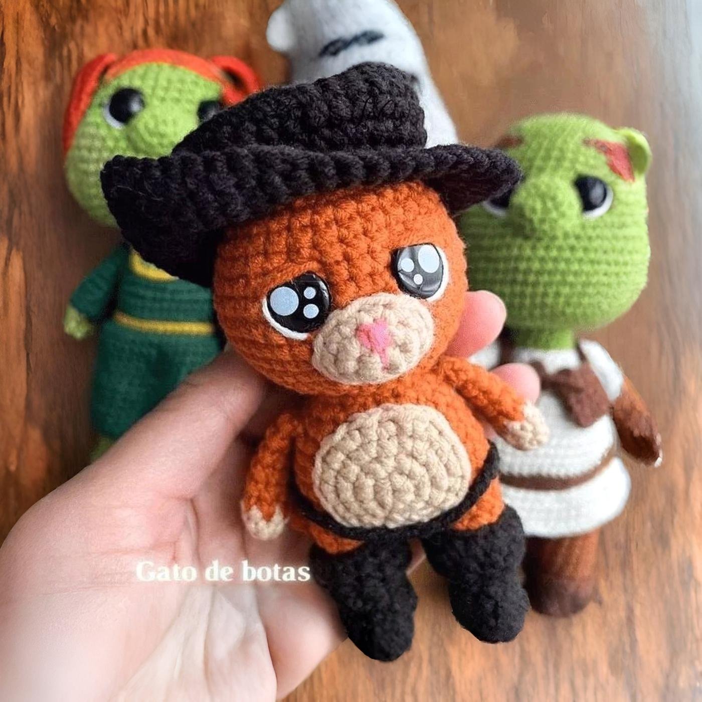 Amigurumi del Gato con Botas terminado, de pie con su sombrero negro y capa, luciendo tierno y heroico
