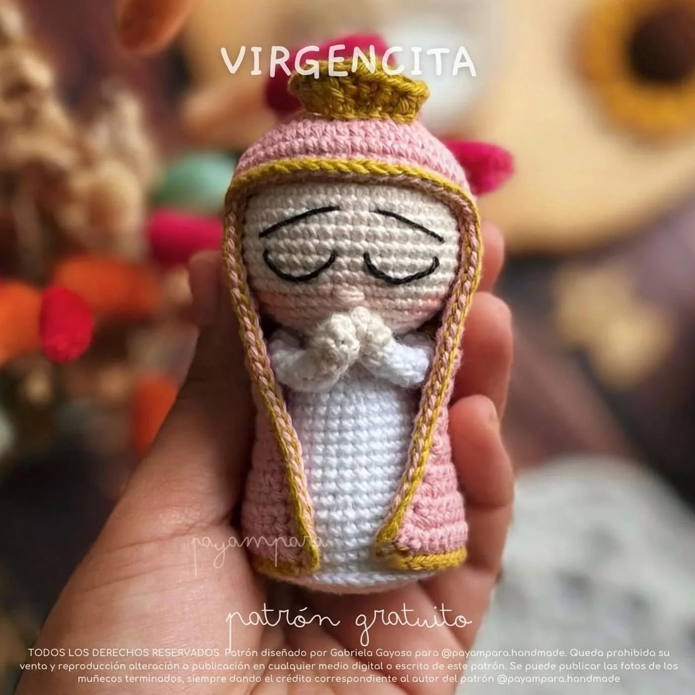 Virgencita amigurumi de crochet terminada, con velo rosa, túnica blanca y manos en posición de rezo.