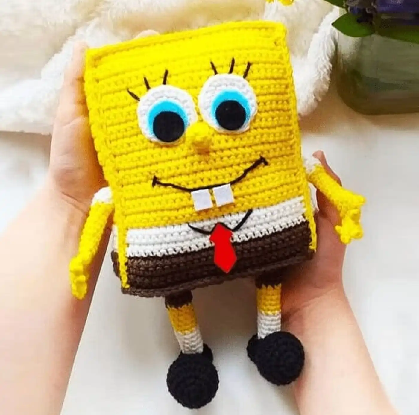 Muñeco amigurumi de Bob Esponja tejido a ganchillo terminado, sobre un fondo neutro.