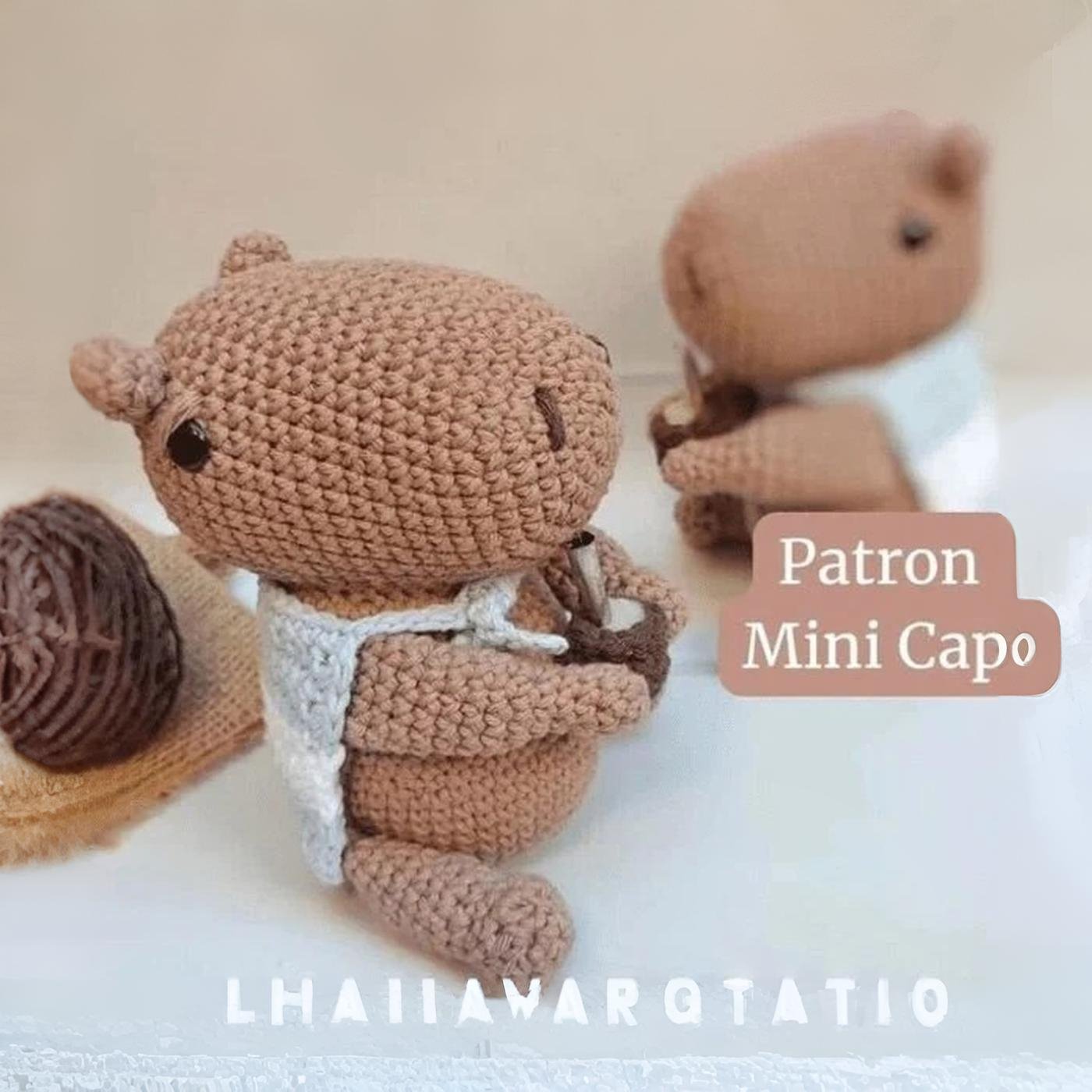 Carpincho amigurumi tejido a crochet sentado, sosteniendo un mate y con una bandera de Argentina.