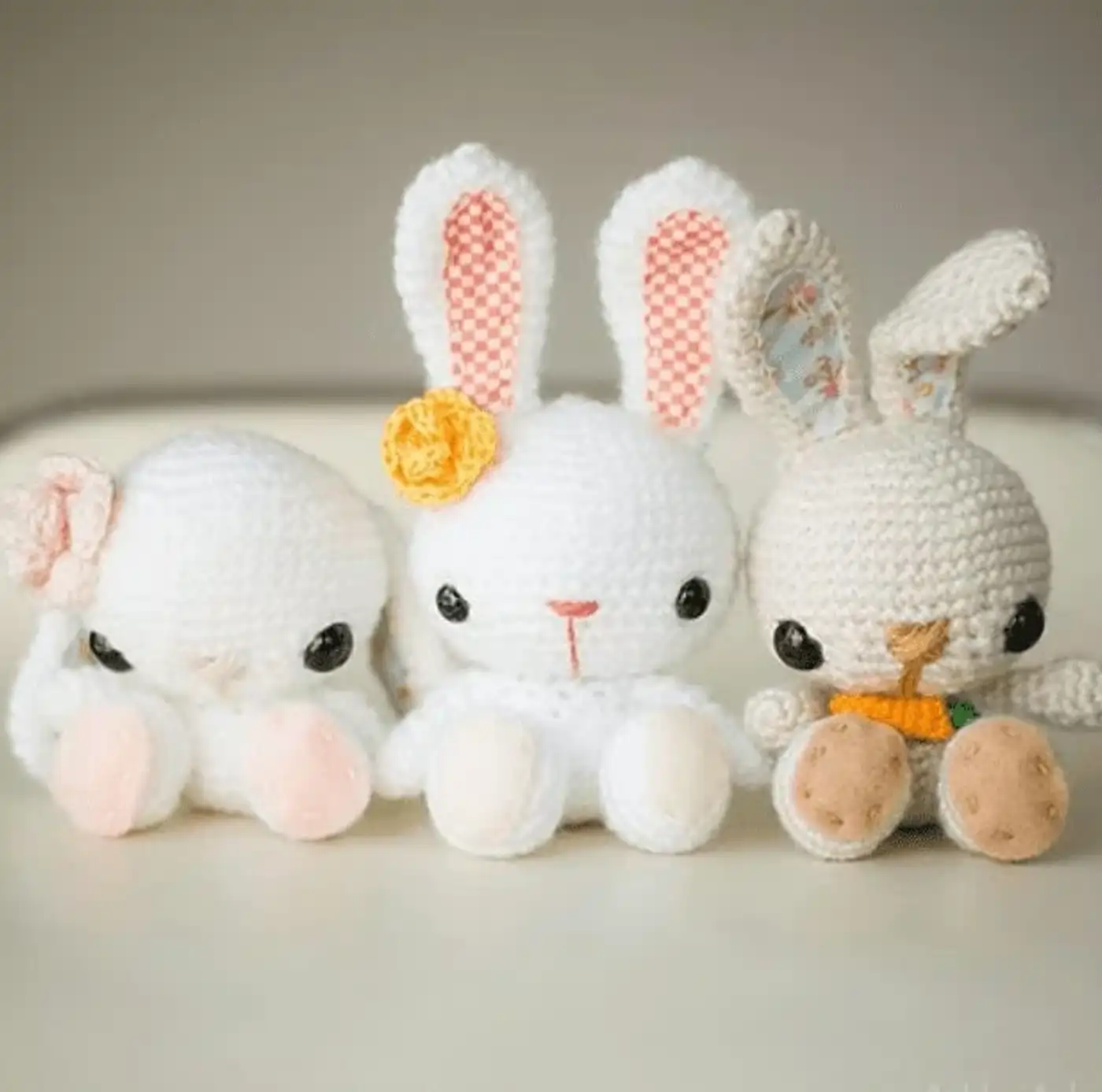 Conejito amigurumi tejido a crochet de color beige con bufanda y zanahoria pequeña