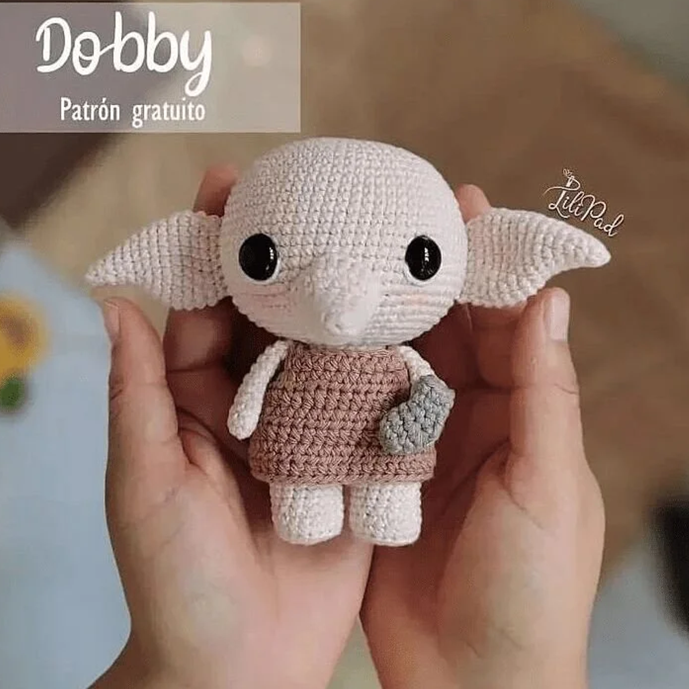 Muñeco tejido de Dobby amigurumi hecho a ganchillo, sentado con su calcetín característico.