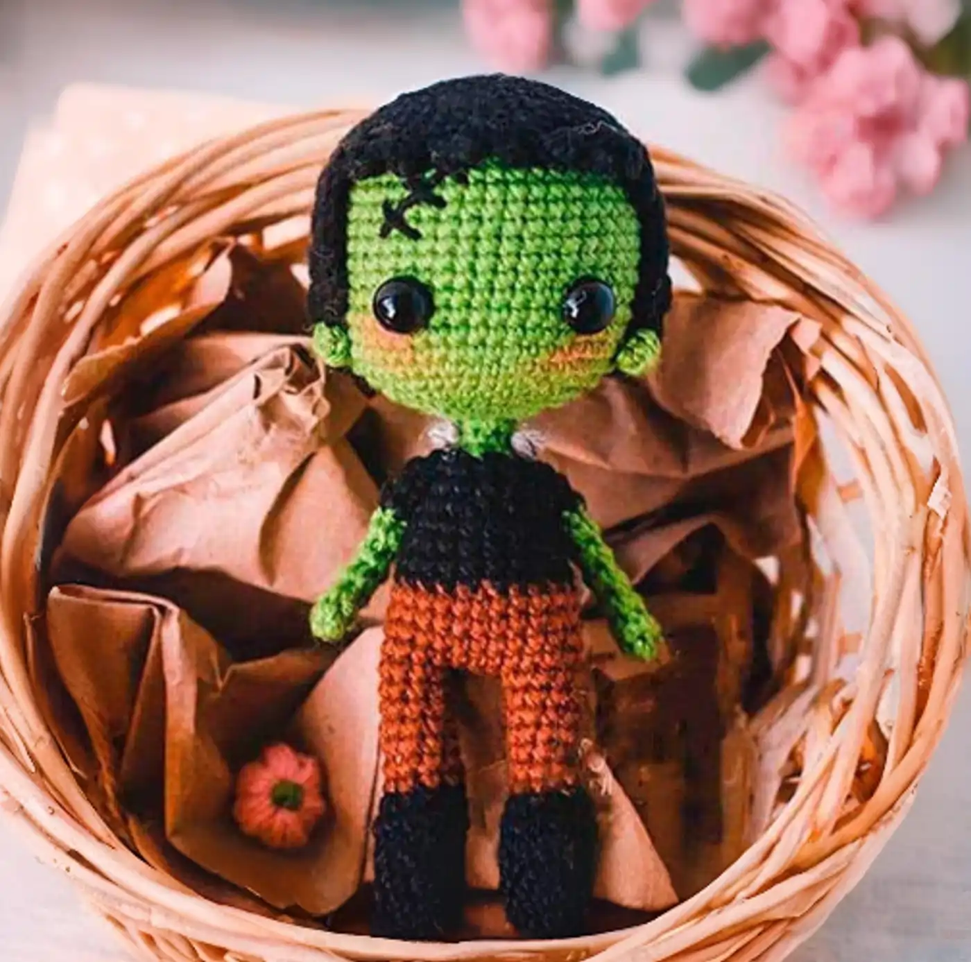 Muñeco amigurumi de Frankenstein tejido a ganchillo con su abrigo marrón y detalles cosidos.