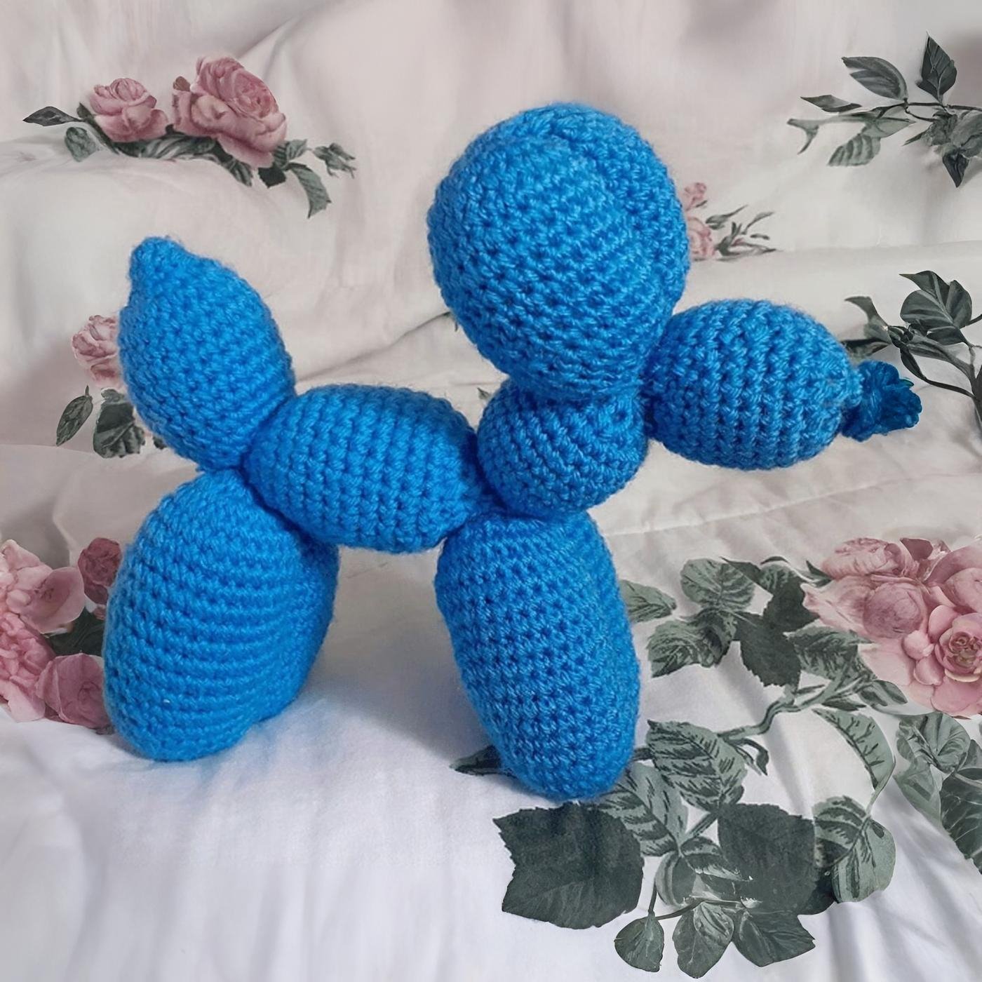Perro globo amigurumi tejido a crochet en color brillante, estilo arte pop, visto de perfil sobre fondo neutro