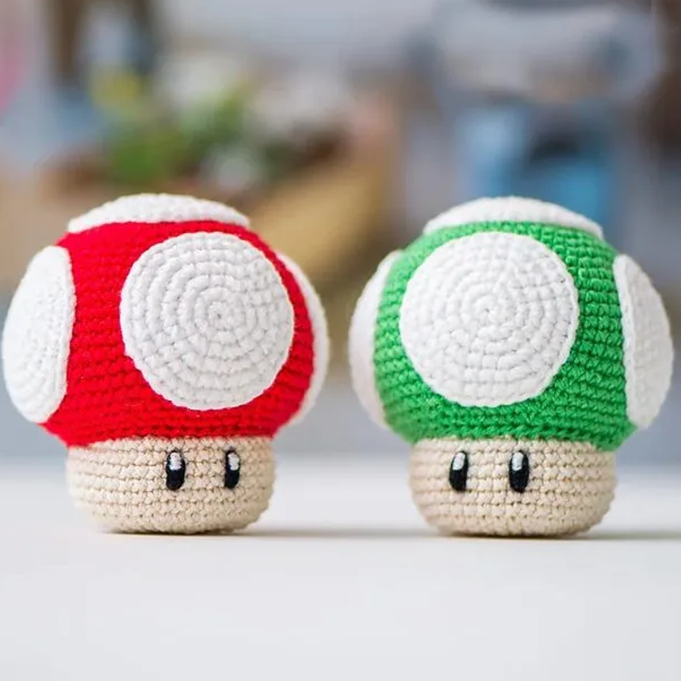 Muñeco amigurumi del hongo verde de Super Mario Bros tejido a crochet, sobre un fondo blanco.