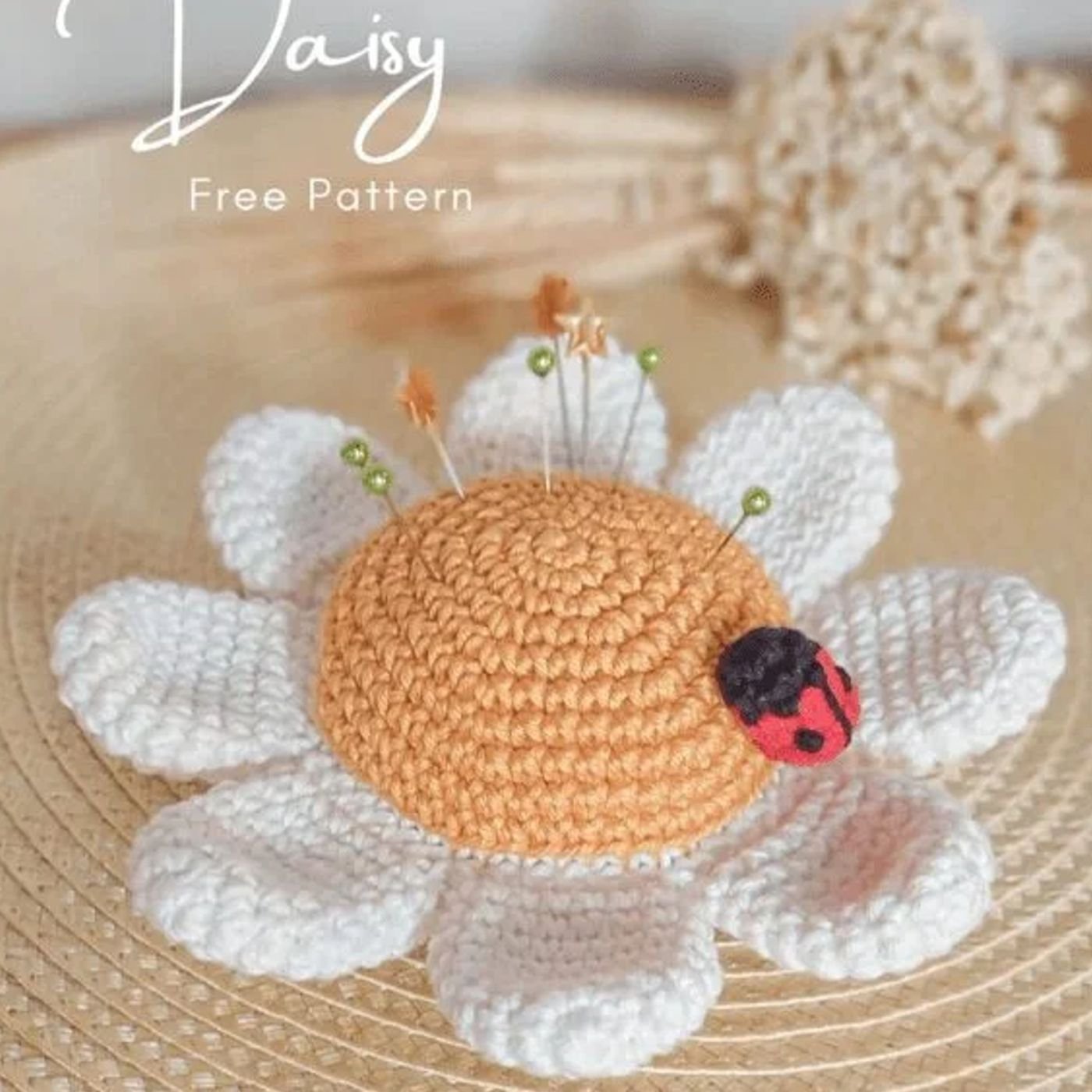 Alfiletero con forma de margarita tejido a crochet con una pequeña mariquita encima