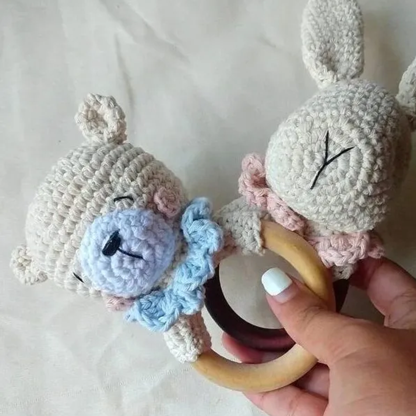 Osito sonajero amigurumi tejido a ganchillo, un juguete para bebés hecho a mano con hilo de algodón y una argolla de madera.