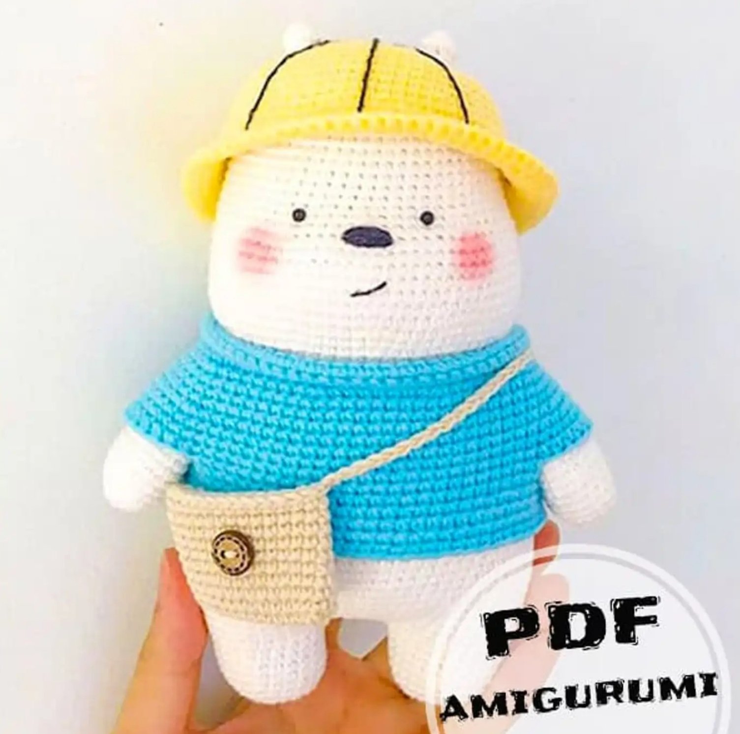 Oso Polar de Escandalosos amigurumi terminado con suéter azul y gorro amarillo tejido a crochet