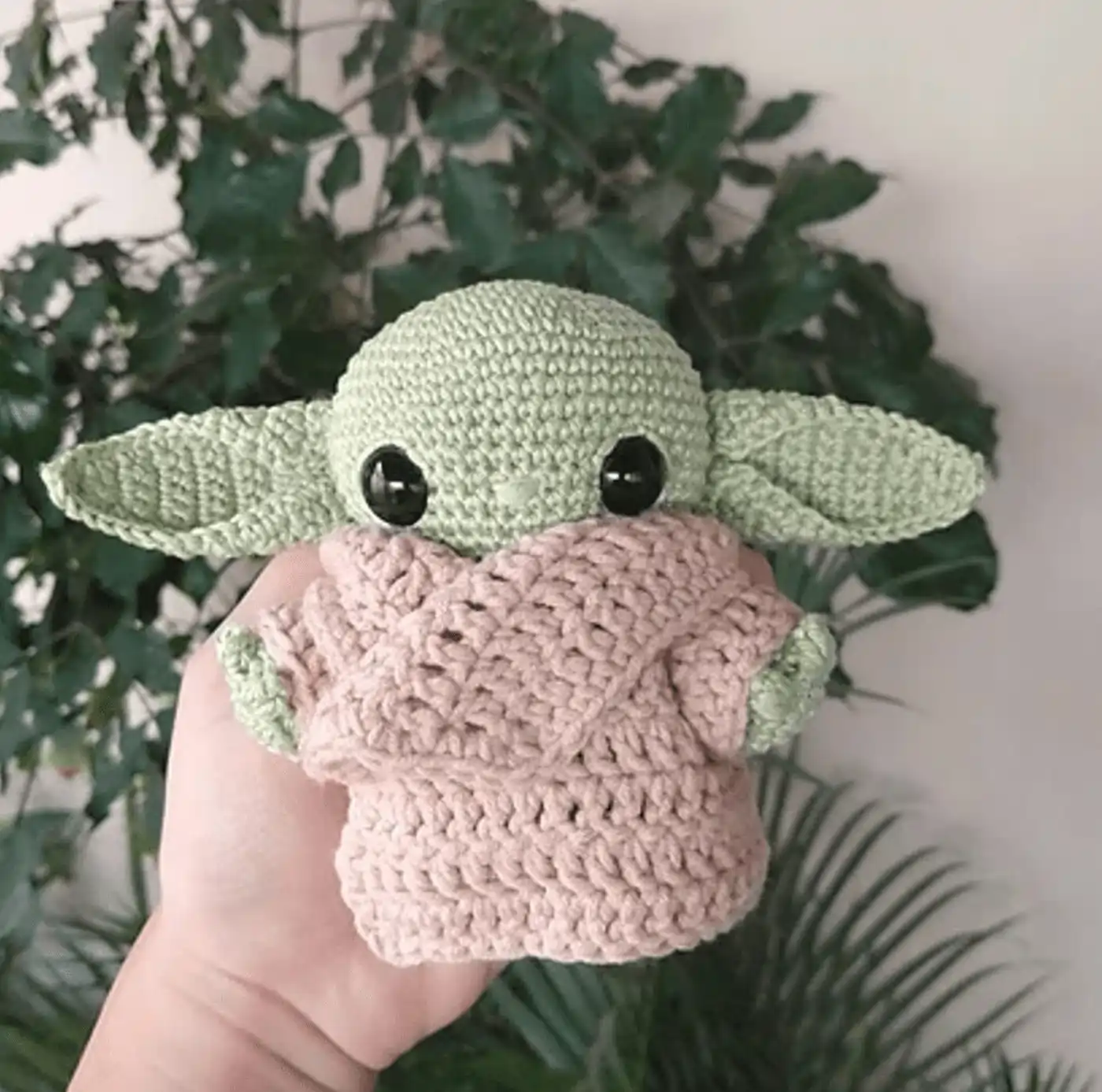 Muñeco amigurumi de Grogu Baby Yoda tejido a crochet con bata beige y expresión tierna