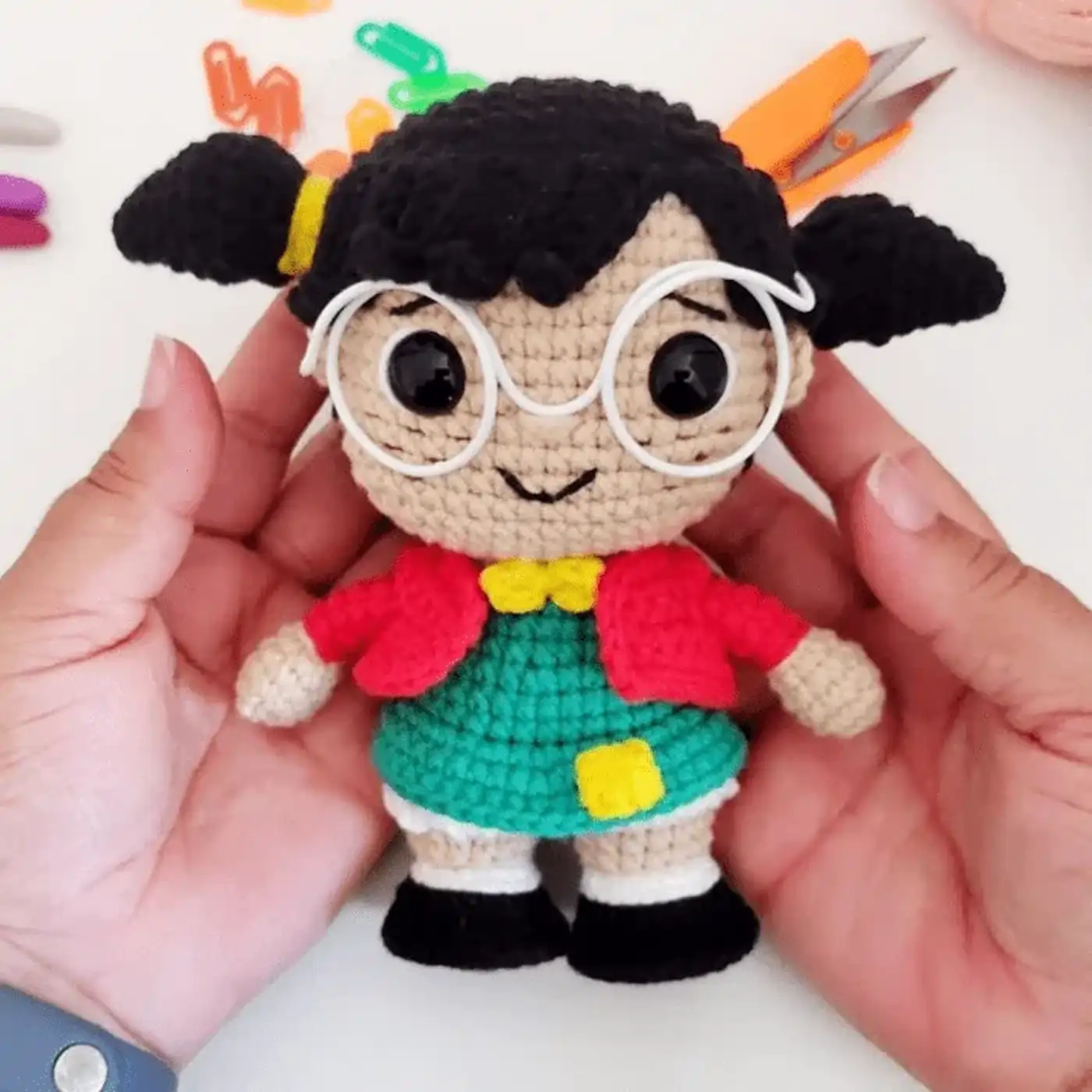 Chilindrina amigurumi terminada con vestido verde y chaqueta roja, usando gafas y peinado característico