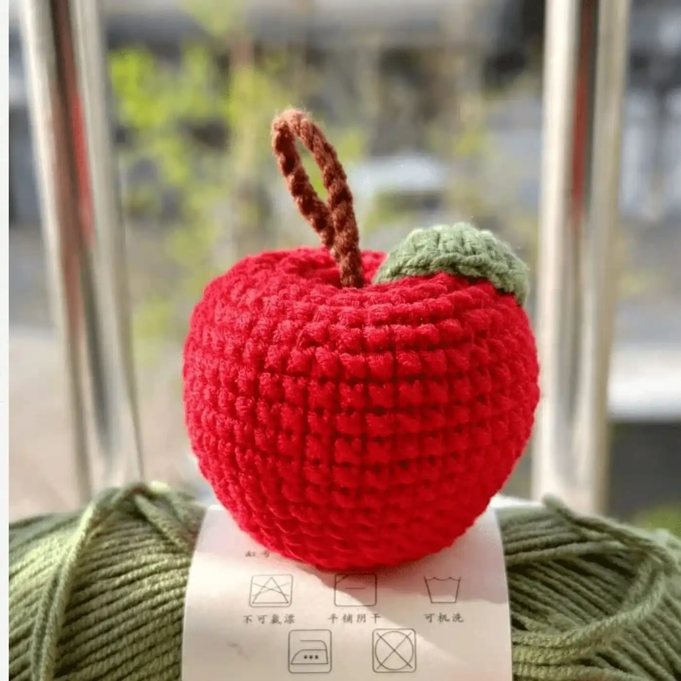 Llavero de manzana amigurumi tejido a crochet en color rojo con hoja verde terminado