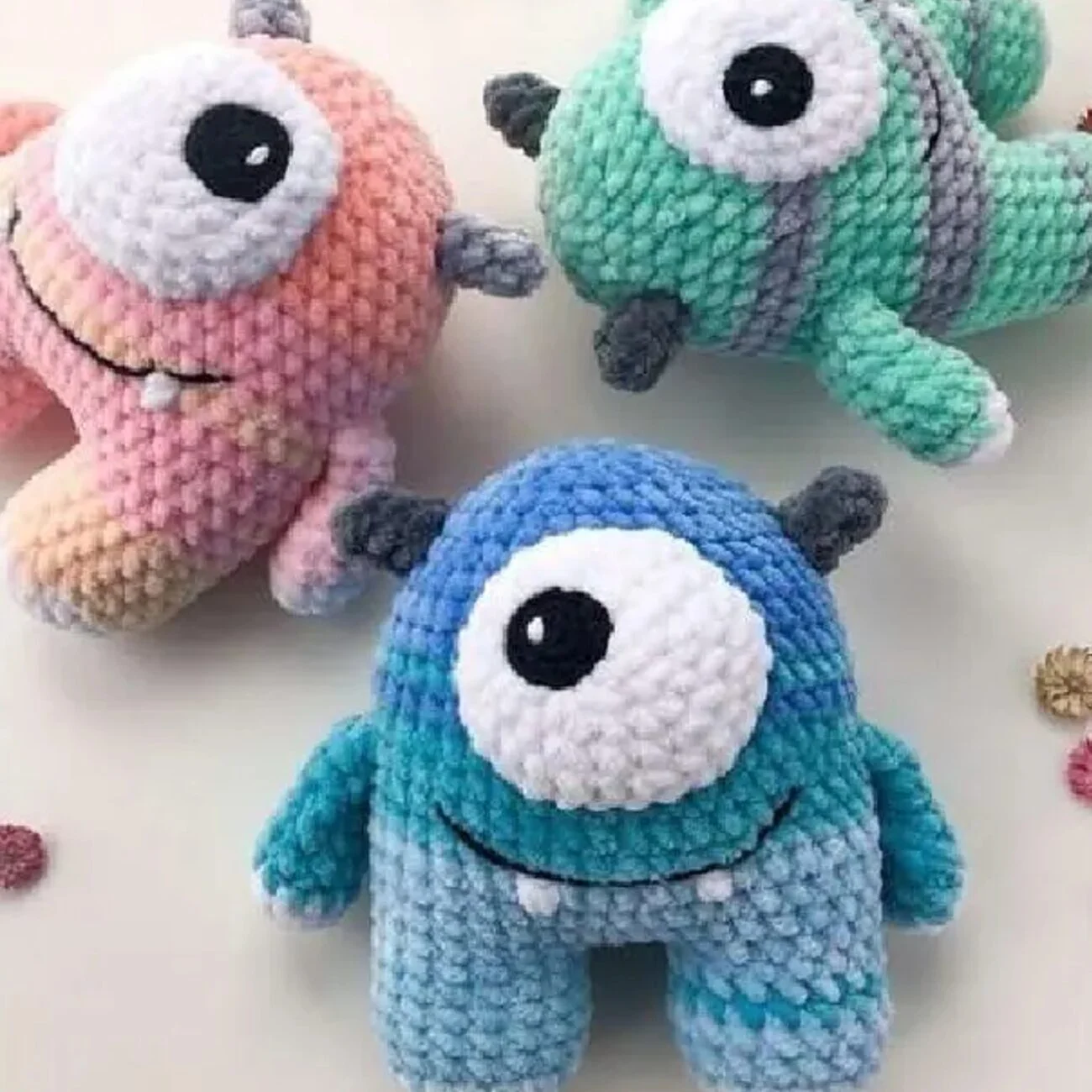 Monstruo amigurumi colorido tejido a crochet con un solo ojo grande y cuernos, patrón gratis paso a paso