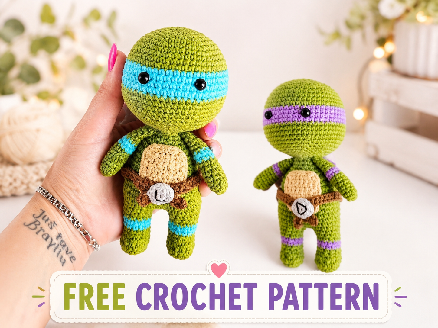 Mano sosteniendo un amigurumi de tortuga ninja con antifaz azul junto a otra tortuga más pequeña con antifaz morado.