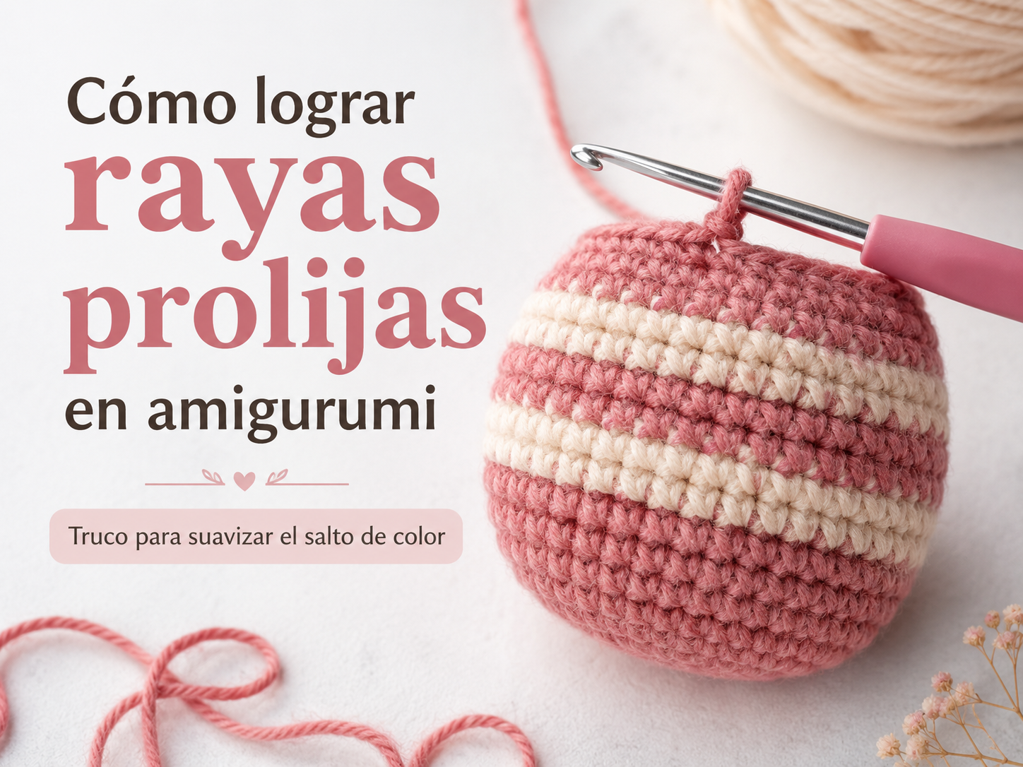 Muñeco de amigurumi a medio tejer con rayas de color rosa y crema, junto a un ganchillo sobre fondo blanco.