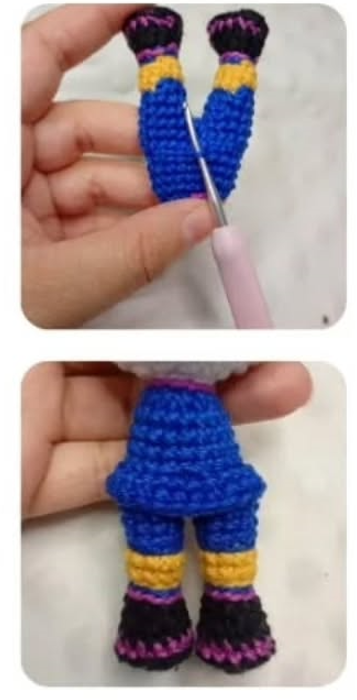 Manos sosteniendo piernas tejidas en ganchillo con colores azul, amarillo y negro, usando una aguja de crochet.