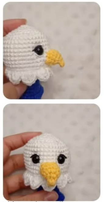 Mano sosteniendo una cabeza de águila tejida en crochet con hilos blanco, amarillo y azul sobre fondo punteado.