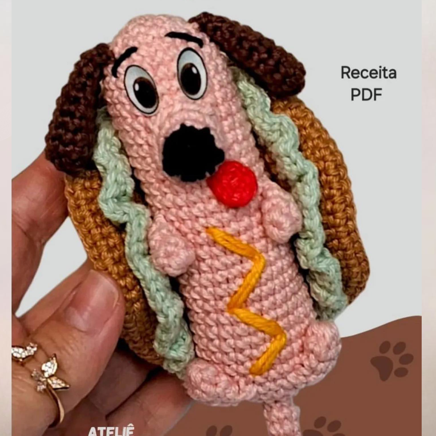 Muñeco de ganchillo hecho a mano con forma de perro salchicha dentro de un pan de perrito caliente
