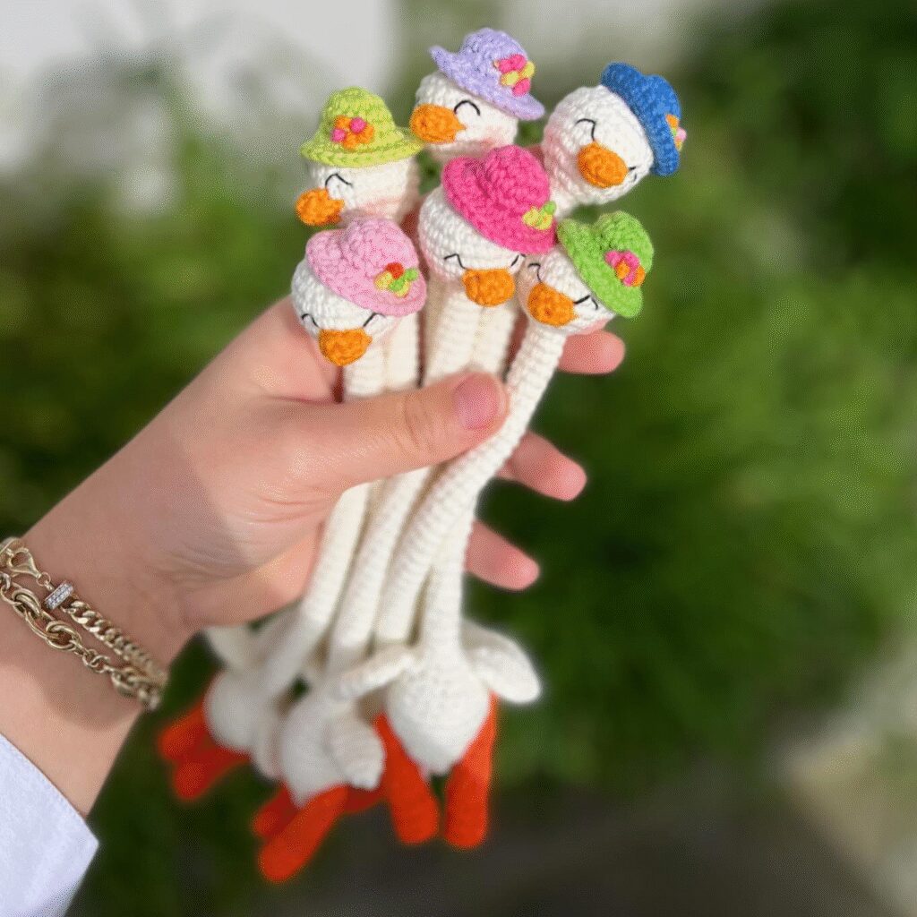 Mano Sosteniendo Adorables Patitos Amigurumi De Crochet Con Gorros Coloridos Patrón Gratuito