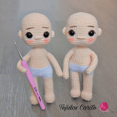 Dos Adorables Muñecos De Bebé Tejidos a Crochet Tomados De La Mano Y Con Pequeños Pañales Blancos