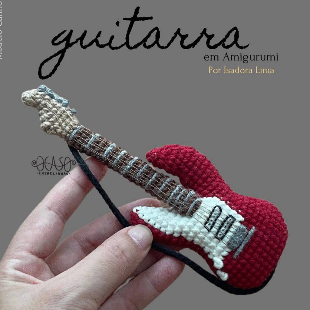 Guitarra Amigurumi De Ganchillo Roja Y Blanca Sostenida En La Mano guitarra En Amigurumi