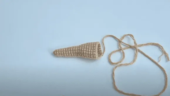 Pieza en forma de cono tejida a crochet con hilo sobrante