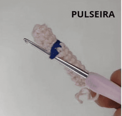 Una Persona Está Tejiendo Una Pulsera Con Un Ganchillo Se Utiliza Hilo De Color Crema Con Una Sección Azul En El Medio La Palabra pulseira pulsera En Portugués Es Visible En La Esquina Superior Derecha De La Imagen Asemejándose a Un Tutorial De Amigurumi En Español O Incluso a Un Proyecto De Amigurumi Goku