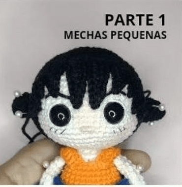 Una Mano Sostiene Una Muñeca Amigurumi Tejida a Crochet Con Cabello Negro Peinado En Pequeños Moños Y Cuentas Blancas La Muñeca Tiene Grandes Ojos Negros Y Lleva Una Blusa De Color Naranja Brillante El Texto Sobre La Muñeca Dice parte 1 Mechas Pequenas Perfecto Para Fanáticos Que Buscan Un Patrón Amigurumi O Un Tutorial De Amigurumi Español