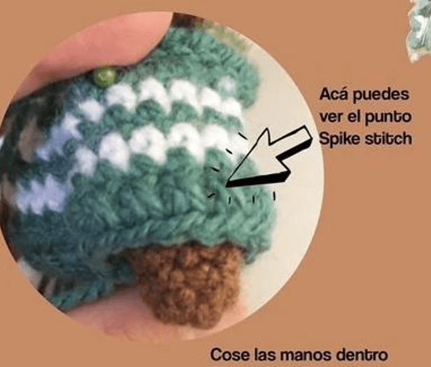 Primer Plano De Una Prenda Tejida a Crochet Que Muestra Un Ejemplo Del Punto Spike La Pieza Se Sujeta Con Una Mano Y El Detalle De La Puntada Está Resaltado Con Una Flecha Negra El Texto Alrededor De La Imagen Dice acá Puedes Ver El Punto Spike Stitch Y cose Las Manos Dentro Consulta Nuestro Crochet En Español Para Más Detalles