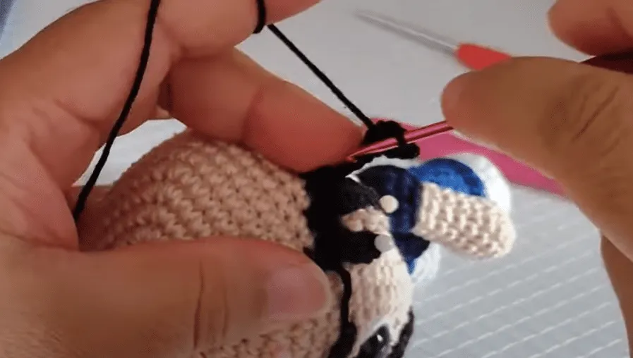 Primer plano de manos tejiendo el gorro amigurumi de Don Ramón.