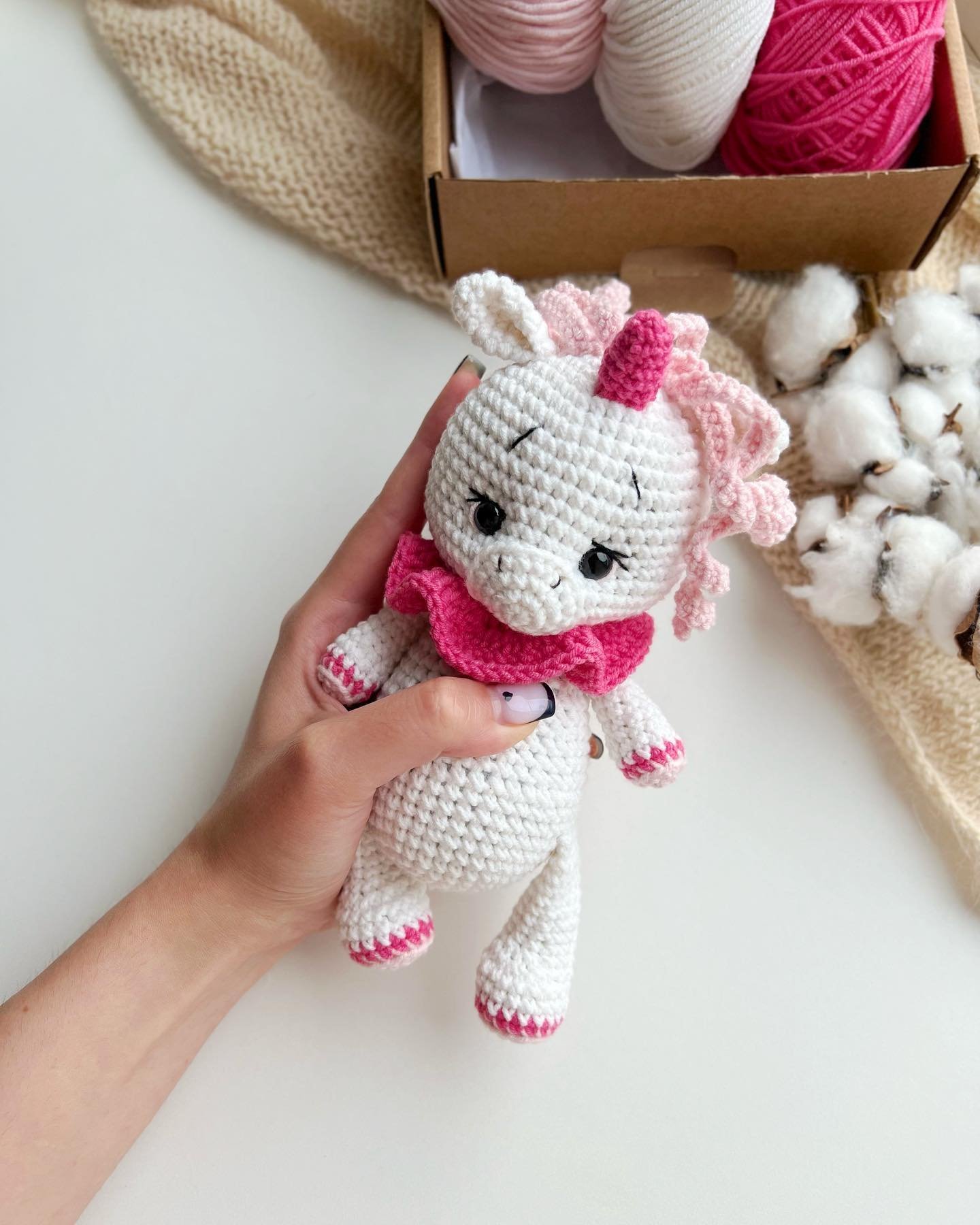 Tierno unicornio amigurumi tejido a crochet de color blanco con melena rizada y cuerno, juguete hecho a mano