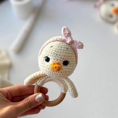Adorable sonajero de patito amigurumi de crochet con lazo rosa. Tutorial de patrón de crochet gratuito.