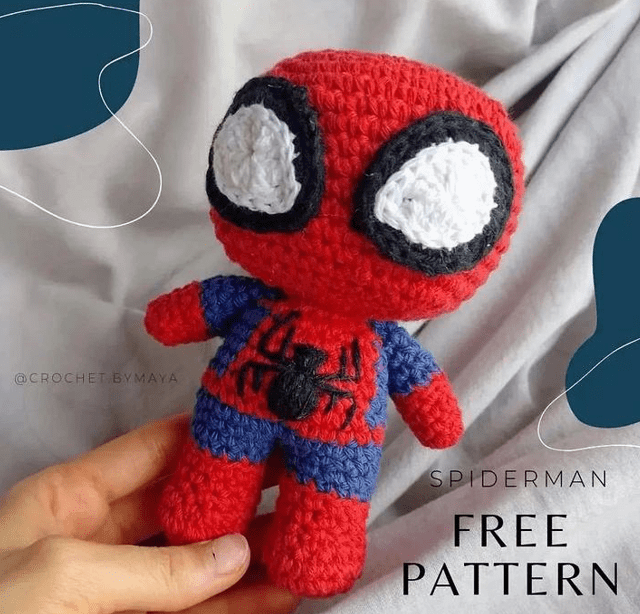 Una Mano Sostiene Un Muñeco De Crochet De Spider man Con Ojos Grandes Y Exagerados Un Traje Rojo Y Azul Y Un Emblema De Araña Negro En El Pecho El Texto De La Imagen Dice patrÓn Gratis De Spiderman Con Un Pequeño Identificador De Instagram crochetbymaya Visible En El Fondo